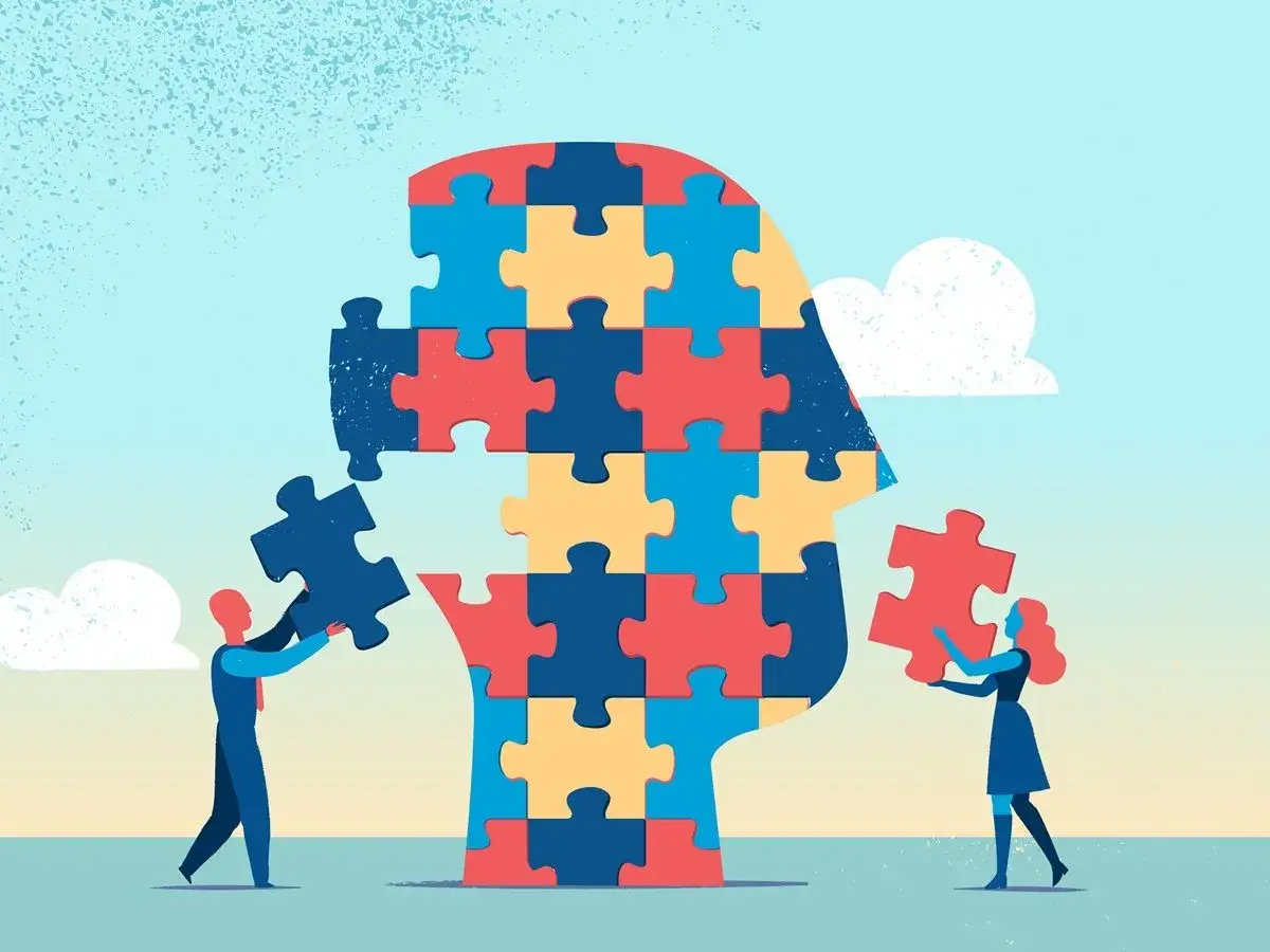 Ludzie składają głowę z puzzli, symbolizując zrozumienie, co to znaczy INFJ – głębokie, intuicyjne poznanie siebie i świata.