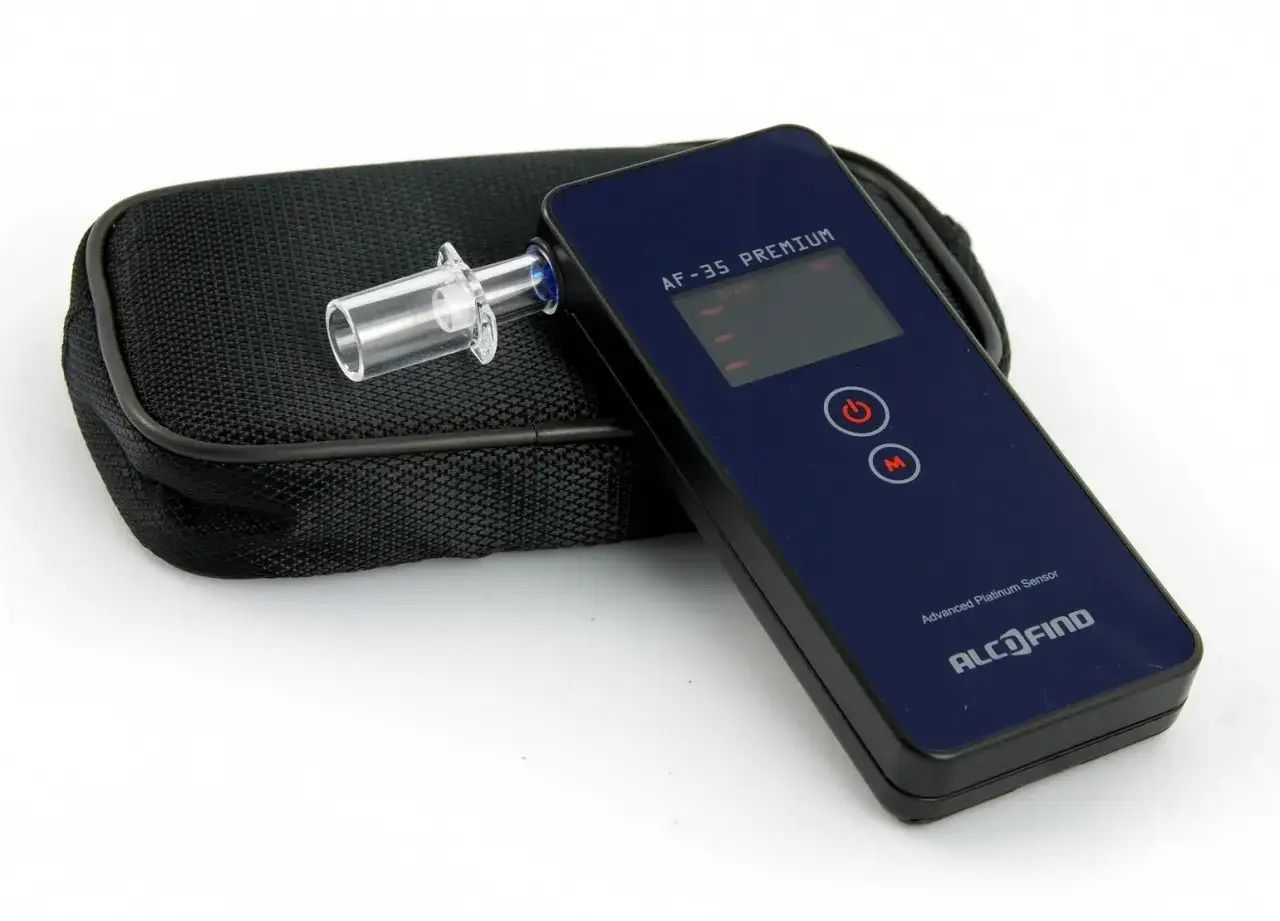 Elektroniczny alkomat z ustnikiem i etui. Urządzenie gotowe do kalibracji, zapewniające dokładne pomiary.