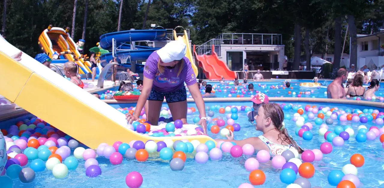 Dzieci bawią się w basenie z kolorowymi piłkami w jednym z polskich aquapark&oacute;w.