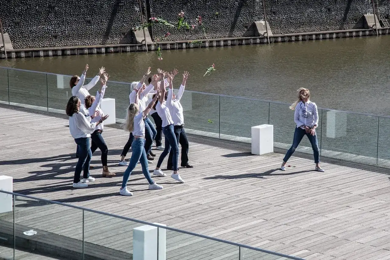 Radosny panieński nad morzem. Grupa kobiet rzuca kwiaty w powietrze, celebrując wspólnie.
