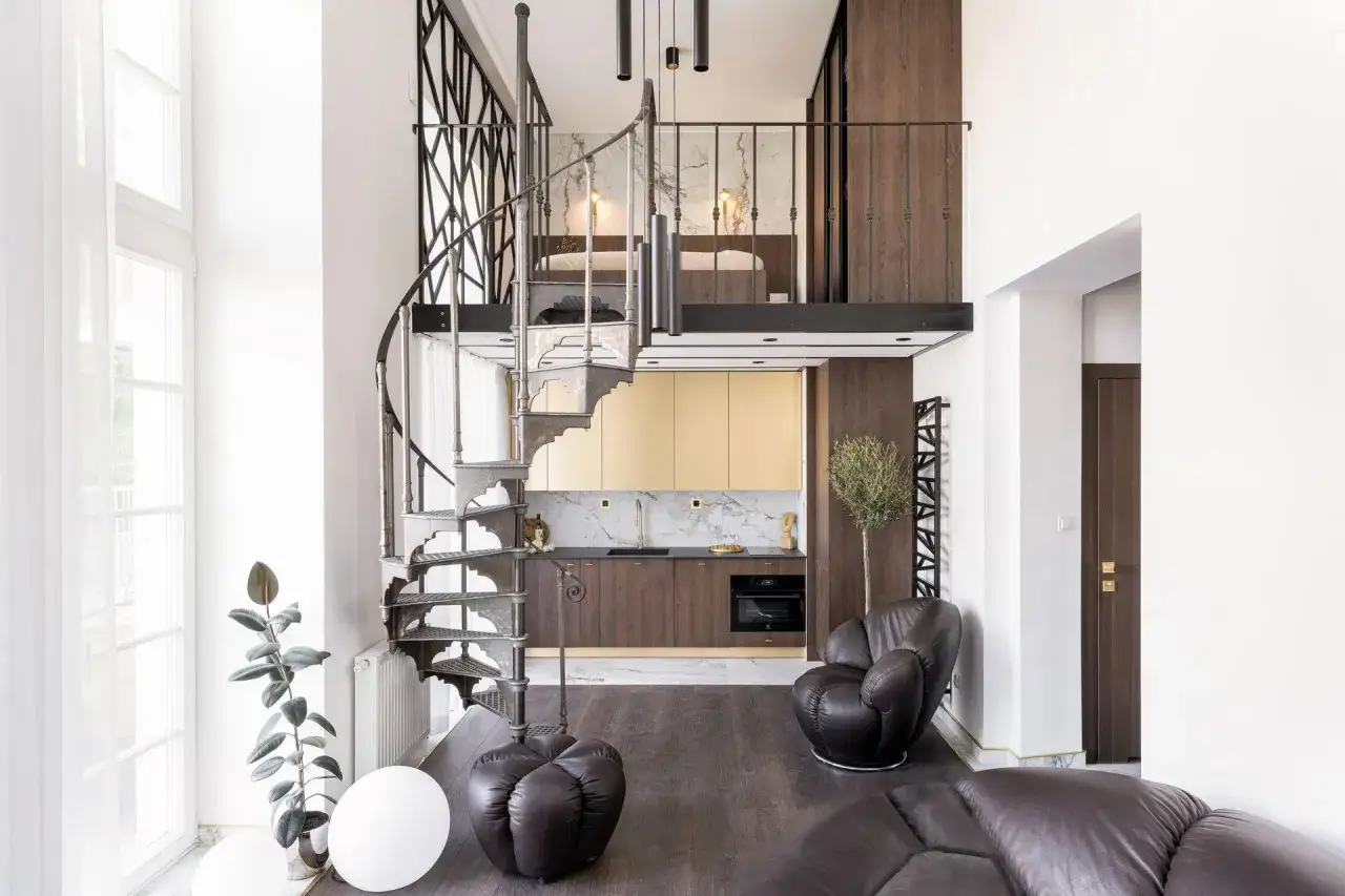 Nowoczesna antresola co to? Widok na dwupoziomowe mieszkanie z kuchnią, sypialnią na g&oacute;rze i krętymi schodami.