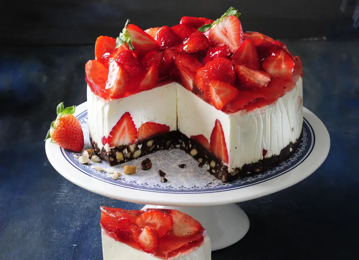Pyszny sernikobrownie z truskawkami, udekorowany świeżymi owocami i galaretką. Idealny deser na każdą okazję.