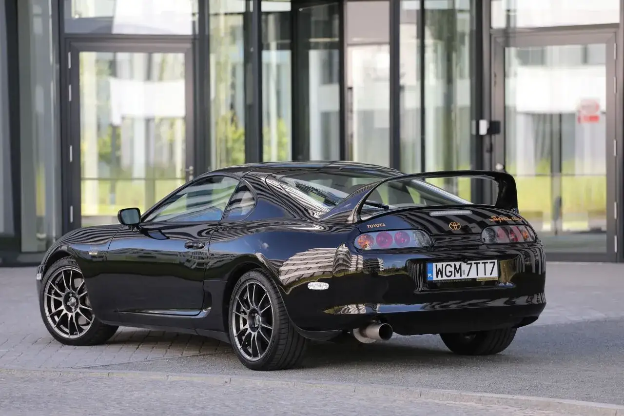 Czarna Toyota Supra z charakterystycznym spojlerem. Zastanawiasz się, ile kosztuje Toyota Supra? To auto marzeń wielu fanów motoryzacji.