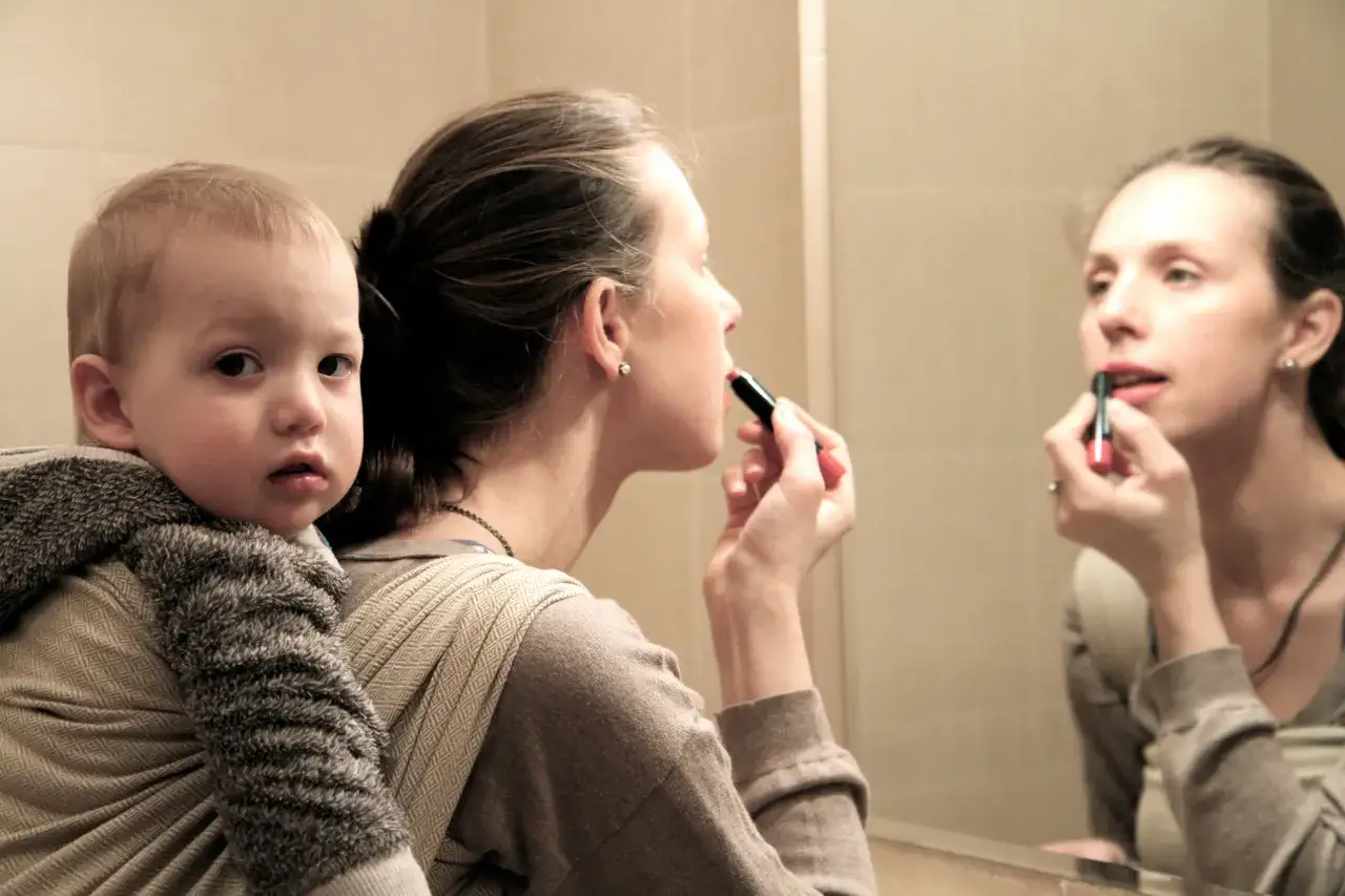 Rodzic bawiący się z niemowlęciem w chuście