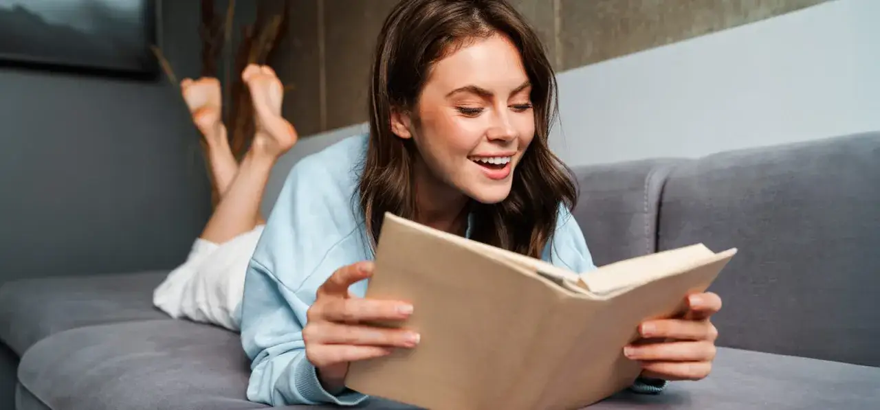 stosik książek rozwojowych, osoba czytająca książkę