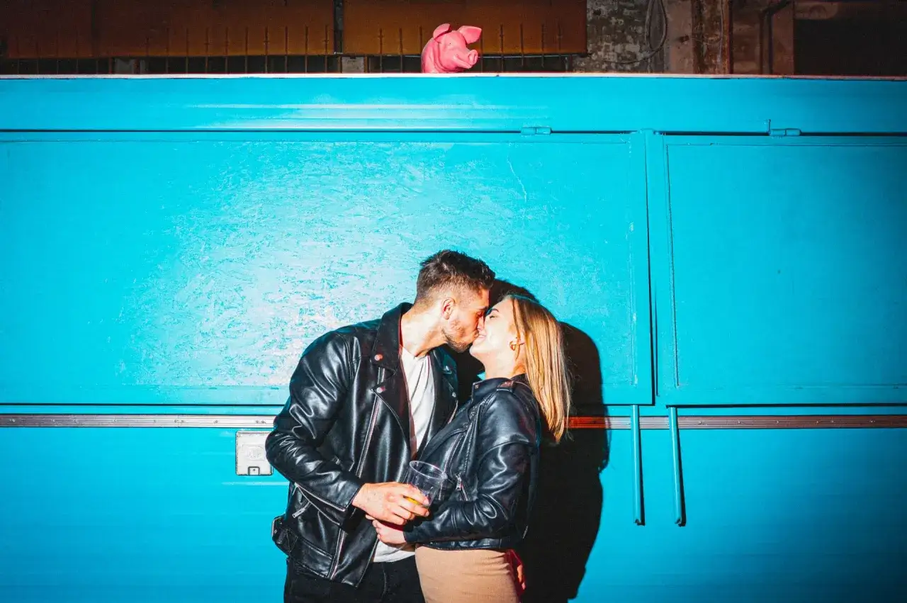 Para zakochanych całuje się na tle niebieskiej ściany. Widać, że to nowy związek po rozstaniu, pełen namiętności i nadziei.