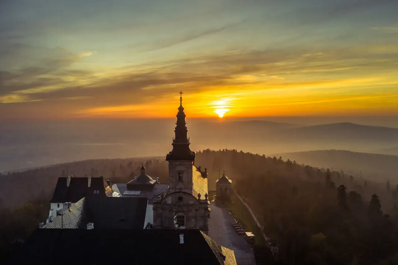 Wsch&oacute;d słońca nad klasztorem na Świętym Krzyżu. Warto zobaczyć to miejsce w G&oacute;rach Świętokrzyskich.