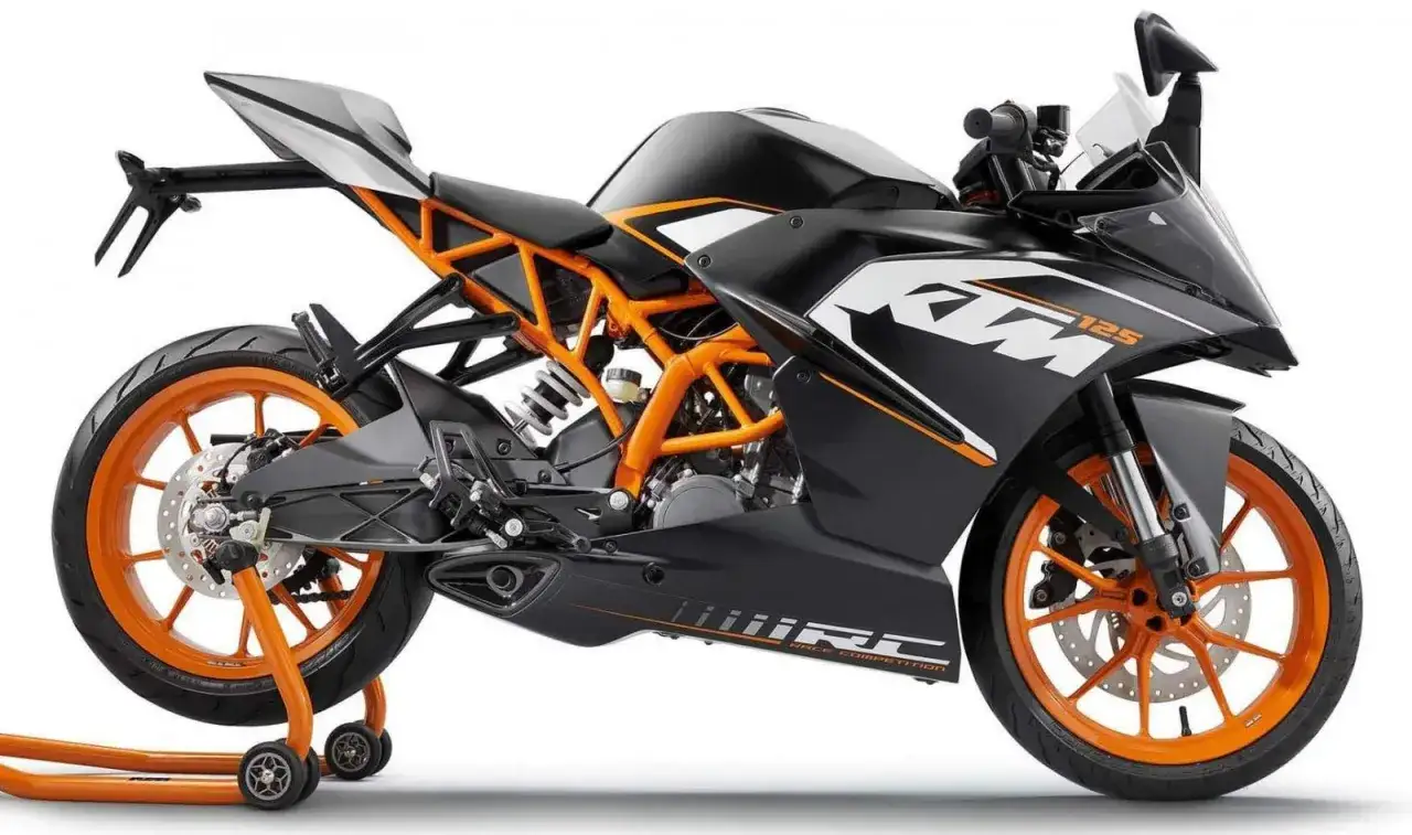 Czarny KTM RC 125 z pomarańczową ramą i felgami, gotowy do osiągnięcia v max.
