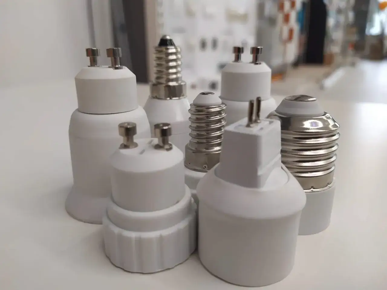 Różne rodzaje gwintów i adapterów do żarówek, w tym gwinty E27, E14 i inne.