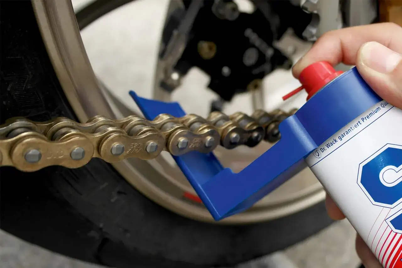 Czyszczenie łańcucha motocyklowego za pomocą specjalnej szczotki i preparatu. Dbałość o napęd to podstawa!