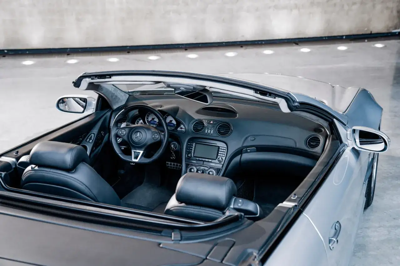 Wnętrze kabrioletu Mercedes SL 63 AMG z czarną skórzaną tapicerką i sportową kierownicą.