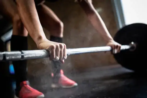 Osoba podnosząca ciężary na siłowni