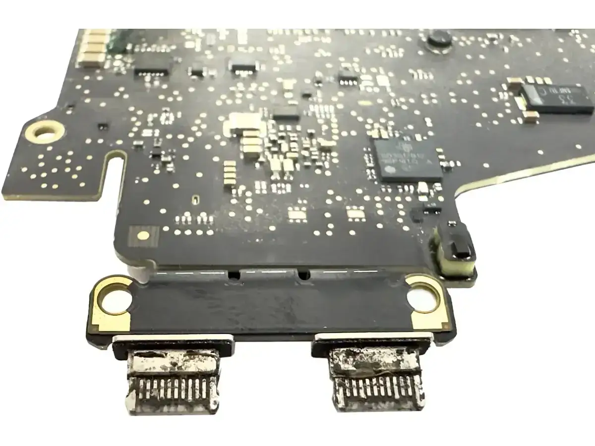 Uszkodzona płyta główna MacBook, z widocznymi dwoma portami USB-C. Prawdopodobna przyczyna, dla której macbook nie włącza się.