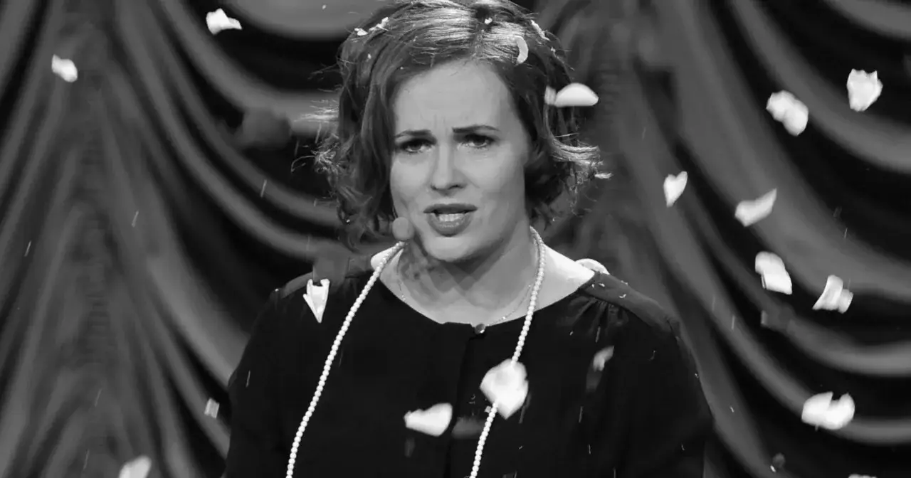 Joanna z kabaretu hrabi, w perłach i płatkach kwiat&oacute;w, na tle zasłony.