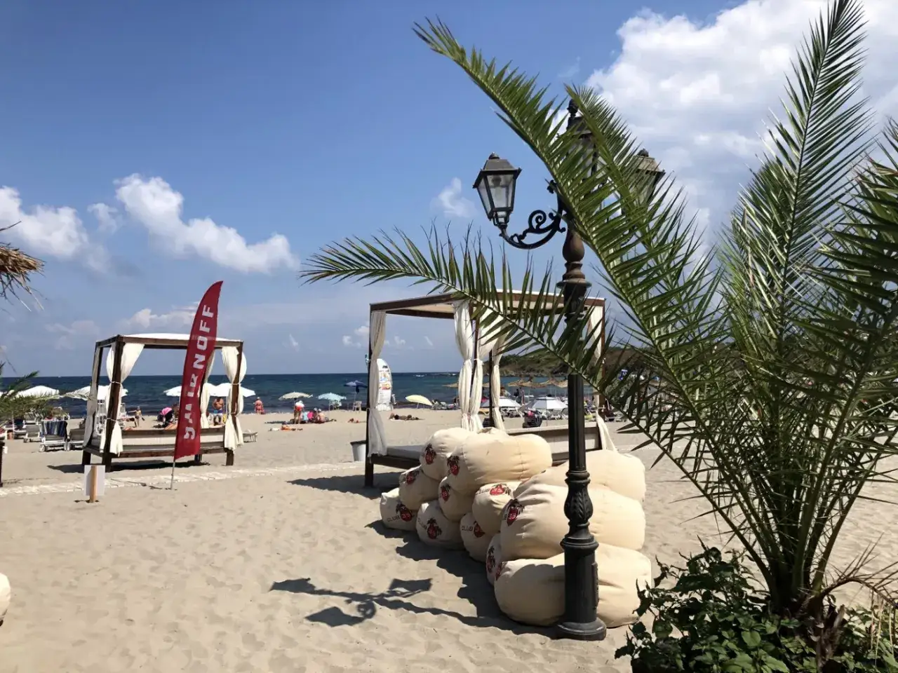 Piękna plaża z leżakami, palmami i lampą. Idealne miejsce na wakacyjne carewo atrakcje.