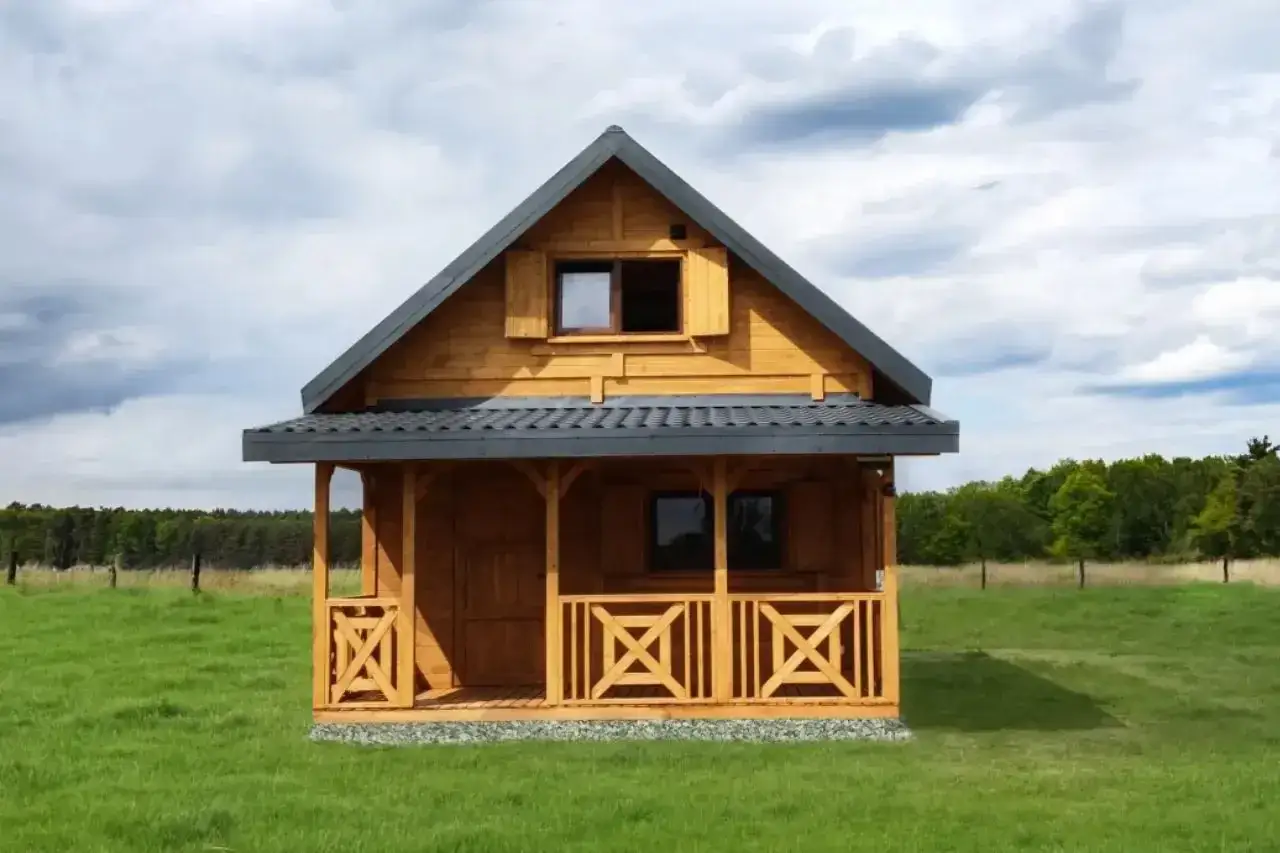 Drewniany domek na działce rekreacyjnej. Zastanawiasz się, ile kosztuje prąd na działce rekreacyjnej?