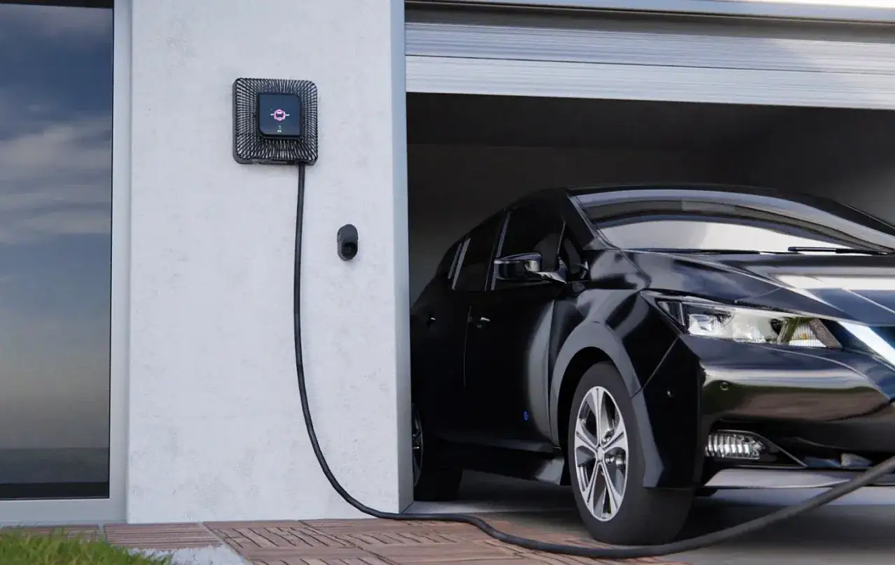 Czarna Tesla ładuje się przy nowoczesnym wallboxie. To stacja ładowania pojazdów elektrycznych, która ułatwia codzienne użytkowanie.