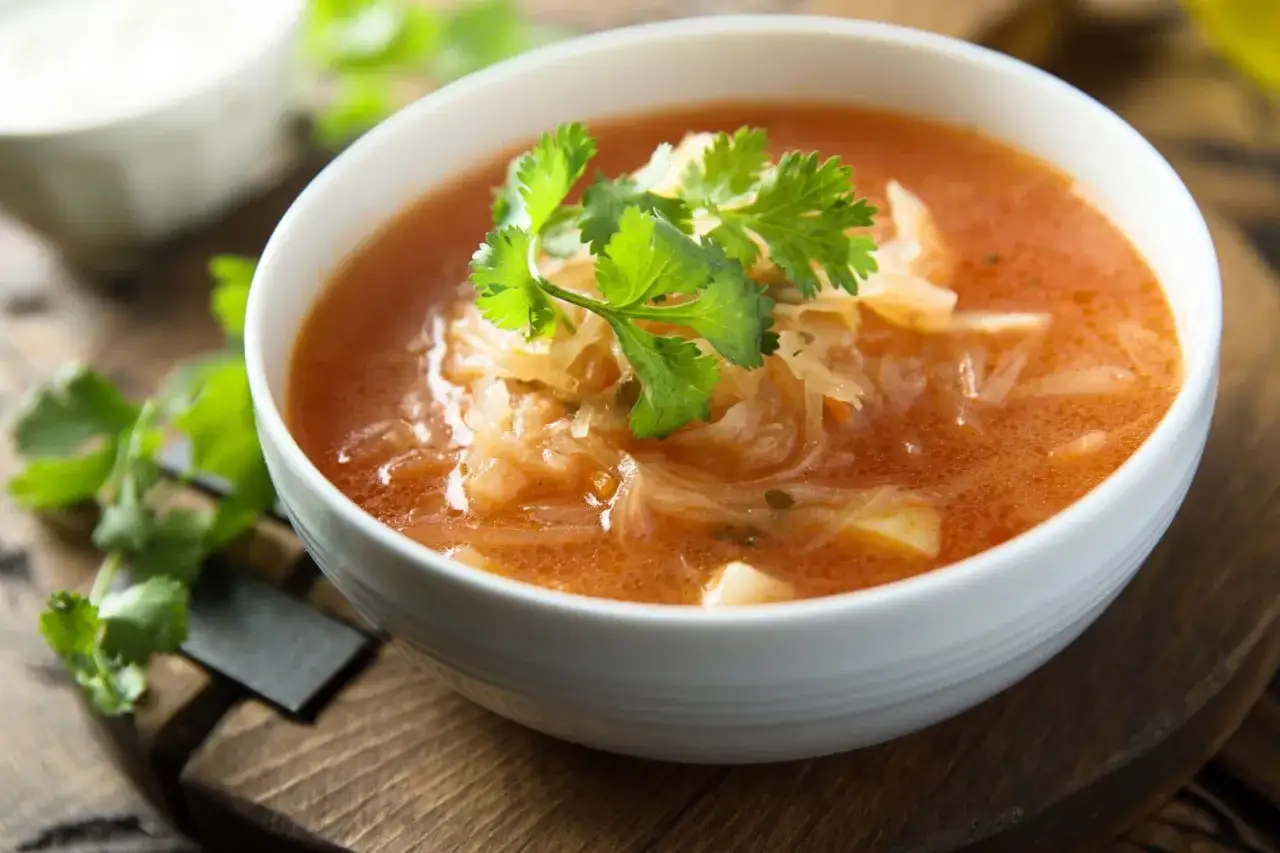 A miseczka parującego kapuśniaku z dodatkiem świeżej kolendry. Idealne przyprawy do kapuśniaku podkreślają jego smak.