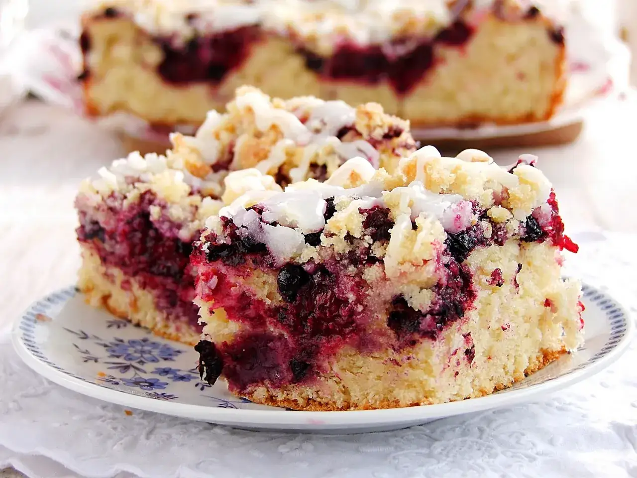 Szybki placek drożdżowy z jagodami i kruszonką, polany lukrem. Idealny na deser.