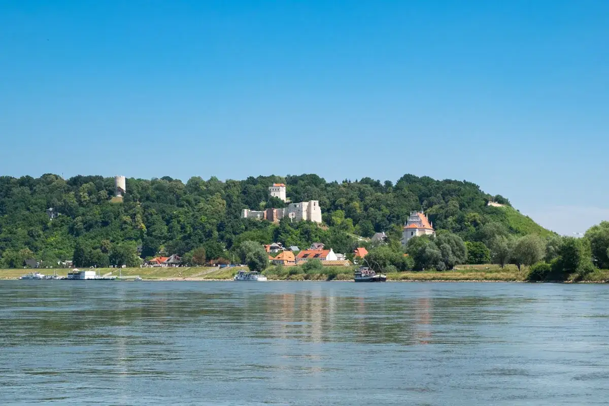 Kazimierz Dolny atrakcje: ruiny zamku, baszta obronna i kościół na wzgórzu nad Wisłą.