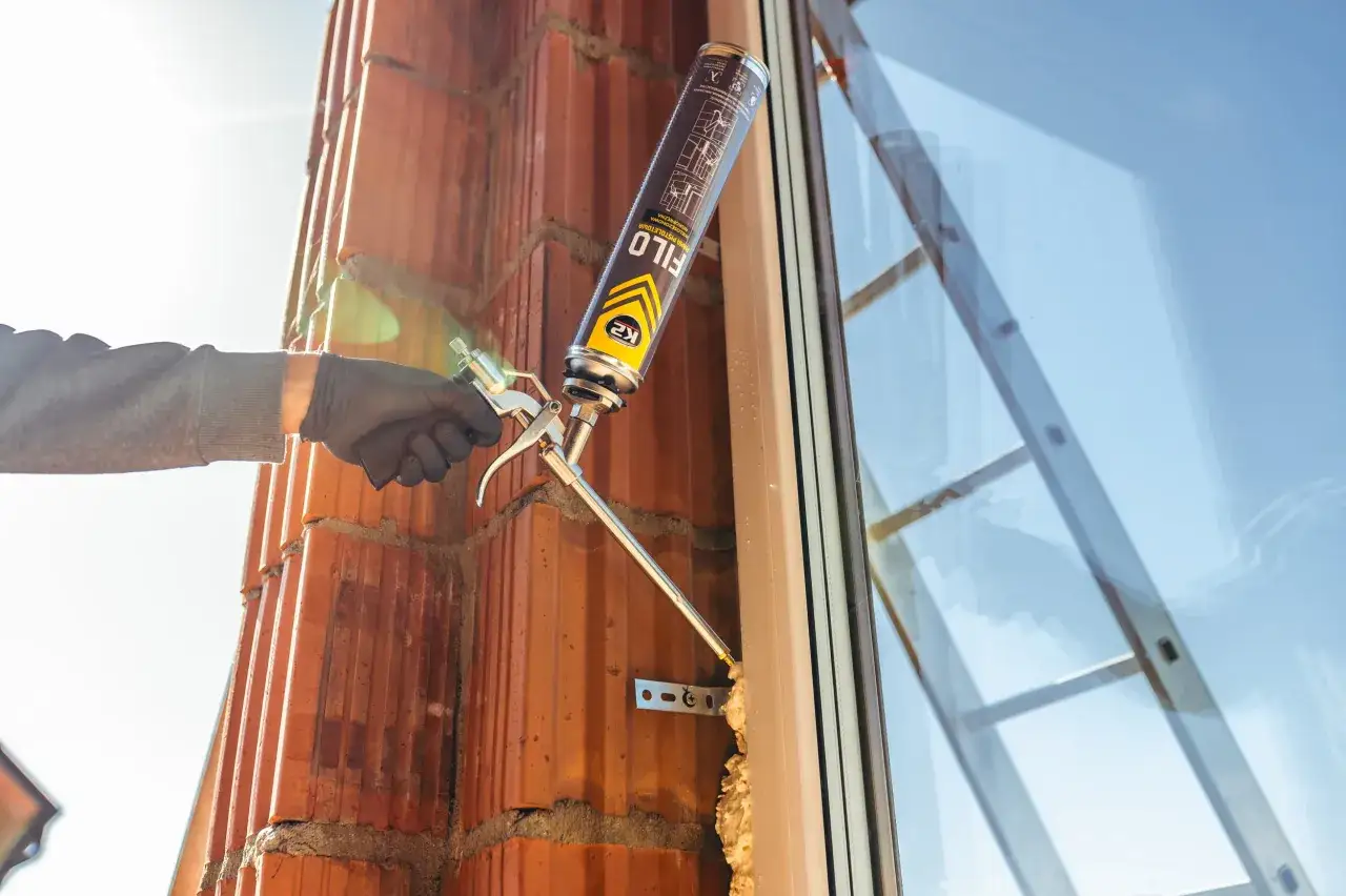 Aplikacja pianki montażowej przy oknie. Zastanawiasz się, ile schnie pianka montażowa? Ten proces jest kluczowy dla izolacji.