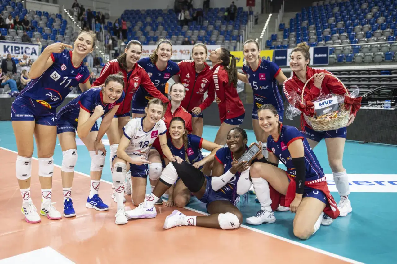 Drużyna siatkarek Budowlani Łódź świętuje zwycięstwo. Widać kosz MVP i statuetki.