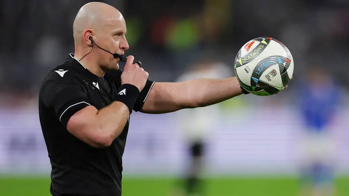 Sędzia piłki nożnej z gwizdkiem na boisku