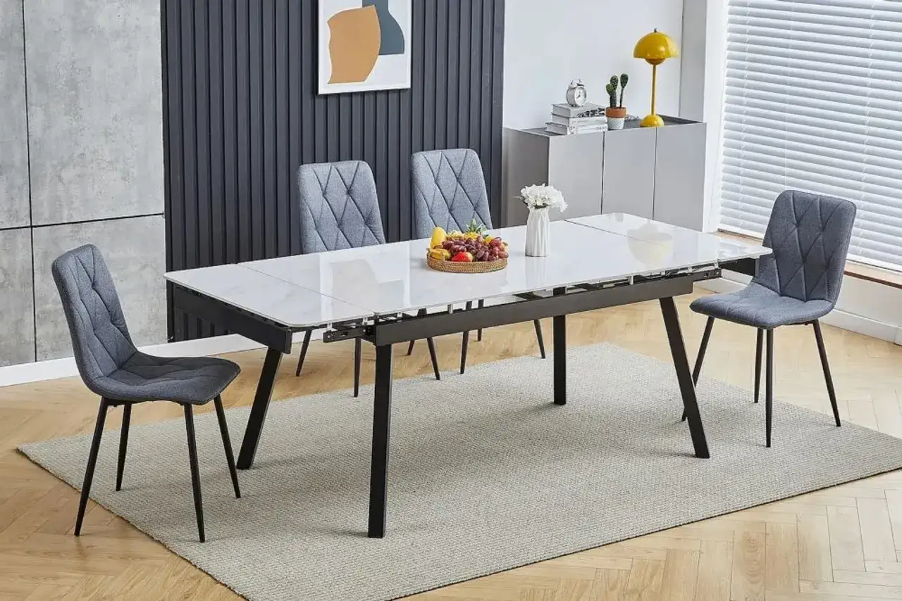 Nowoczesna jadalnia: biały st&oacute;ł z marmurowym blatem, szare krzesła, koszyk z owocami. Idealne co na ścianę w kuchni przy stole i krzesłach.