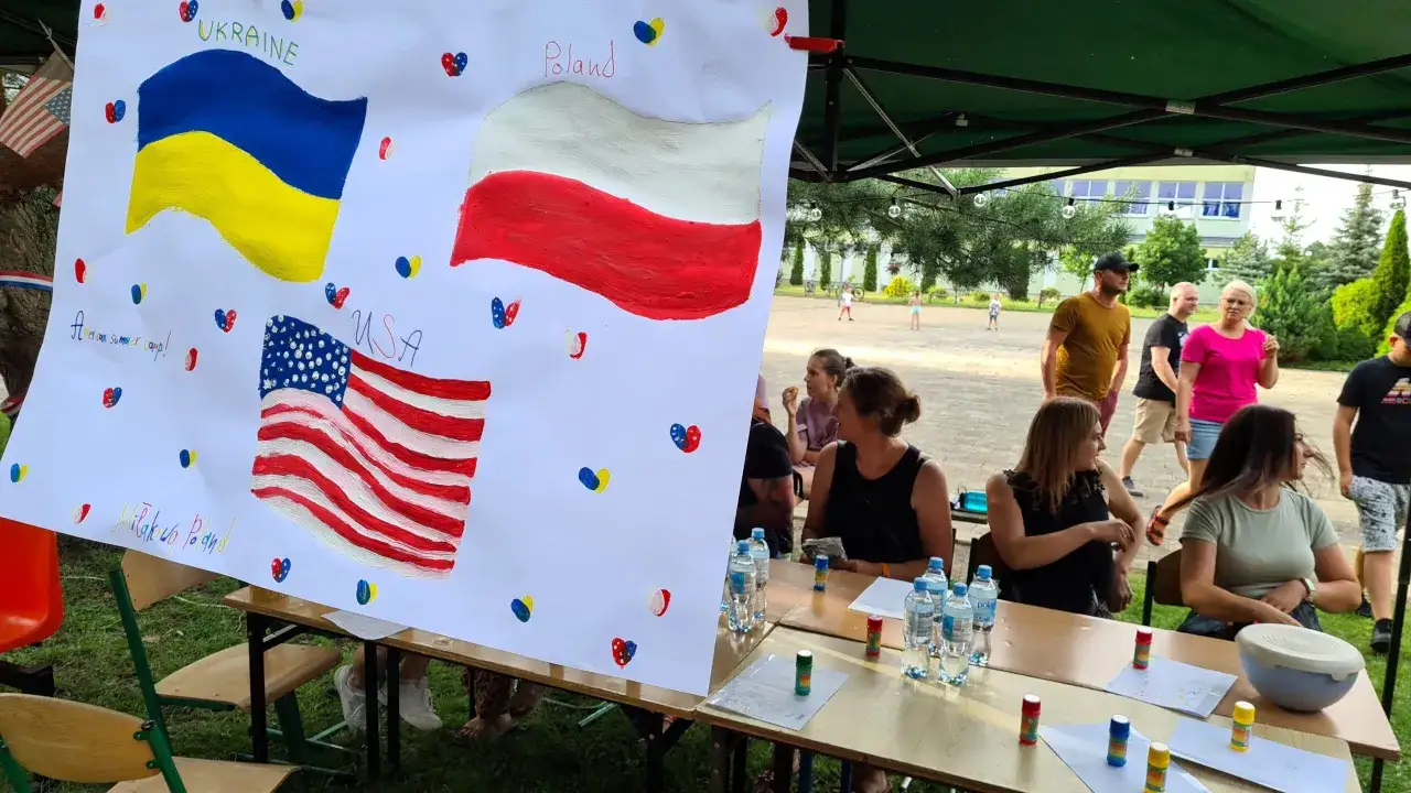 Obóz językowy w Polsce? Na plakacie flagi Ukrainy, USA i Polski. Dzieci malują, dorośli obserwują.