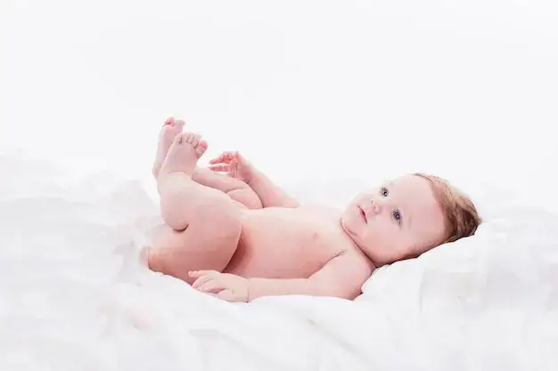 uśmiechnięte niemowlę leżące na plecach