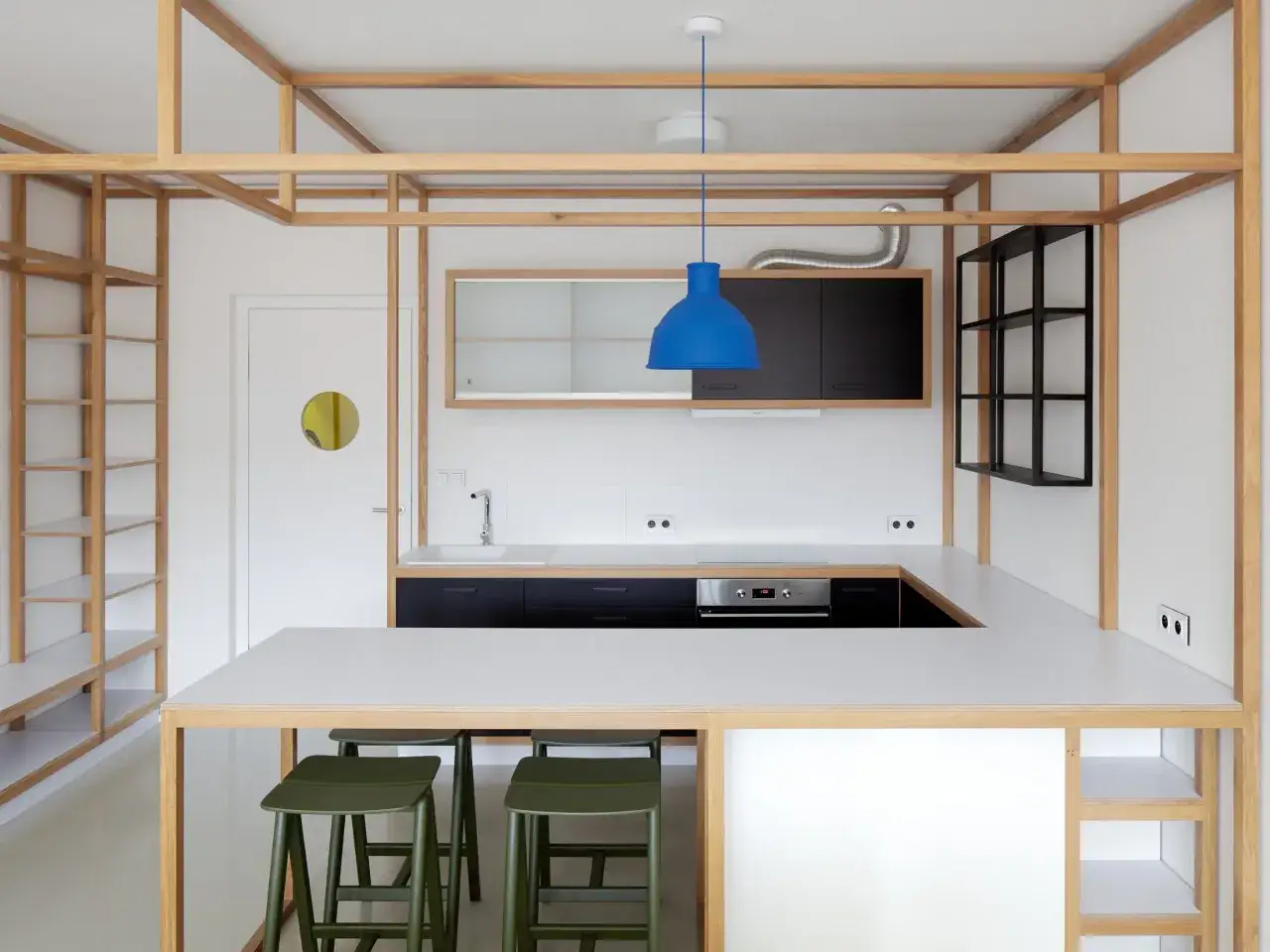 Nowoczesny schowek w mieszkaniu z drewnianą ramą, czarnymi szafkami kuchennymi i niebieską lampą.
