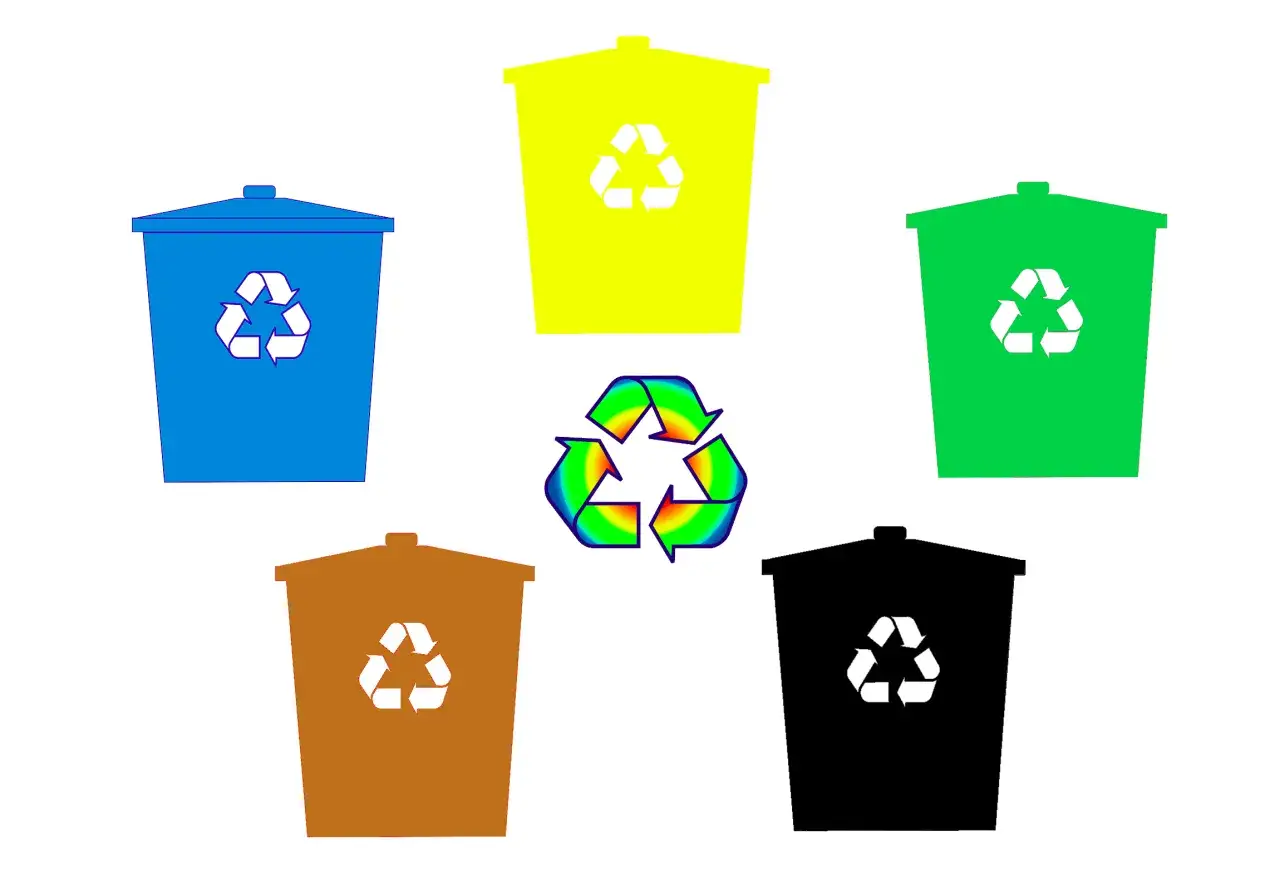 Kolorowe kosze na śmieci z symbolami recyklingu. Różne znaki na opakowaniach informują o segregacji.