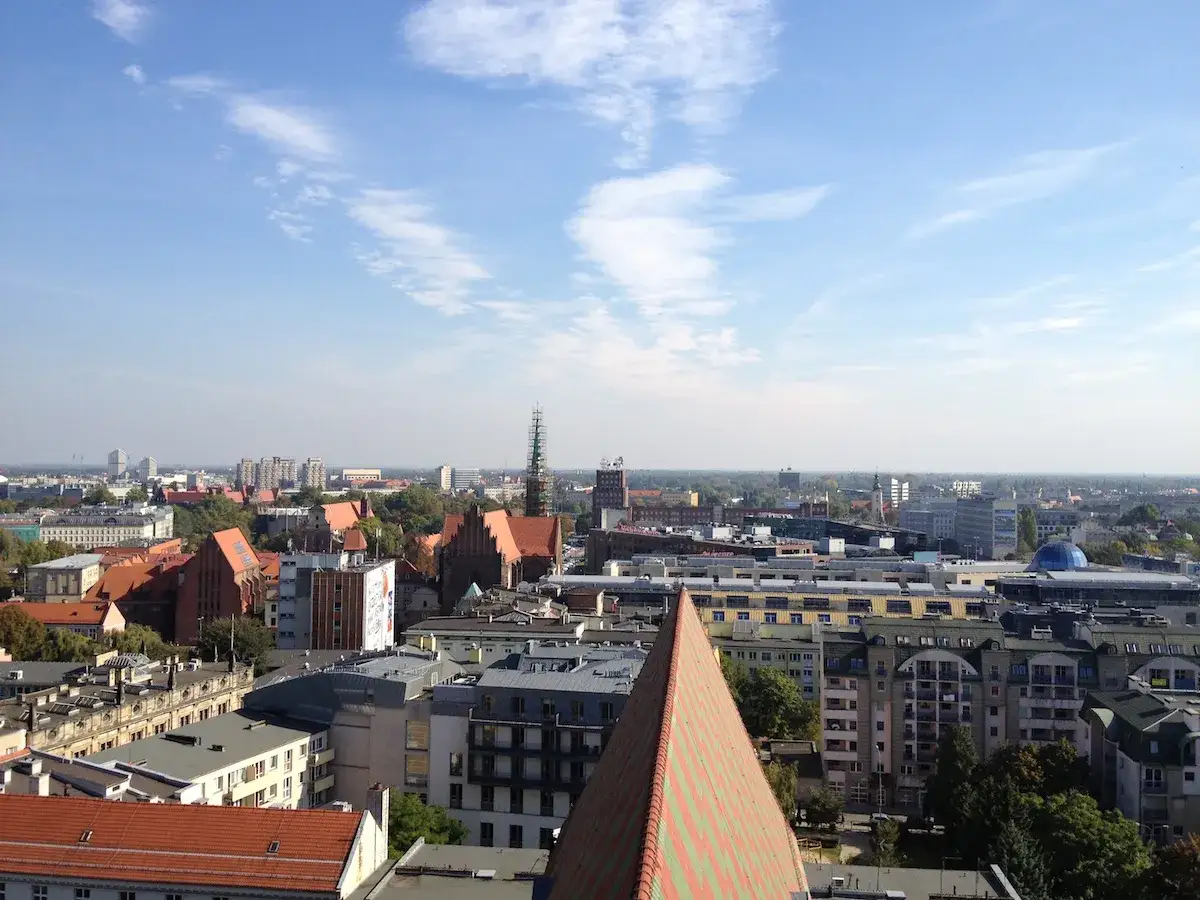 Widok z punktu widokowego Wrocław na dachy kamienic i wieże kościołów.