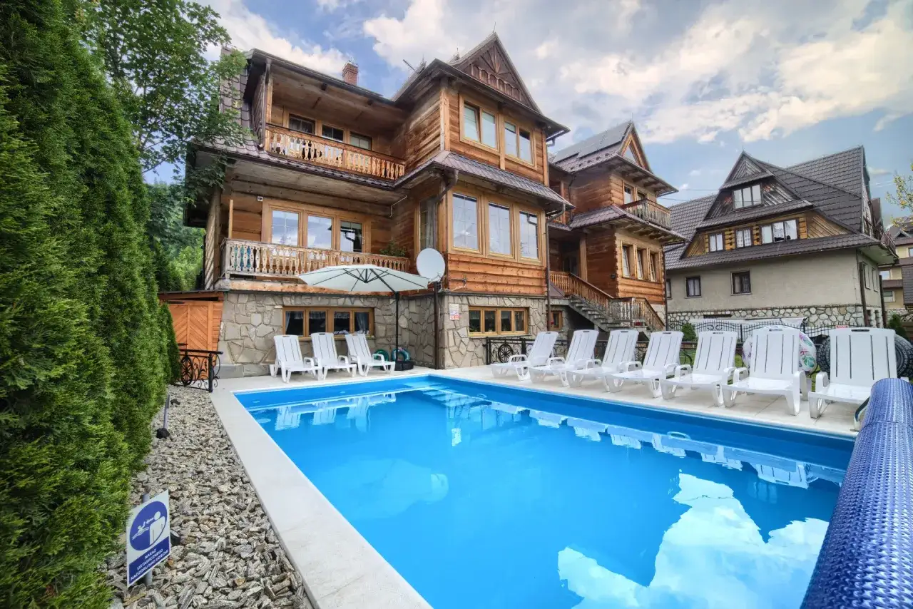 Drewniany dom z basenem i leżakami. Szukasz sposobu, jak znaleźć tani nocleg? To miejsce może być inspiracją!