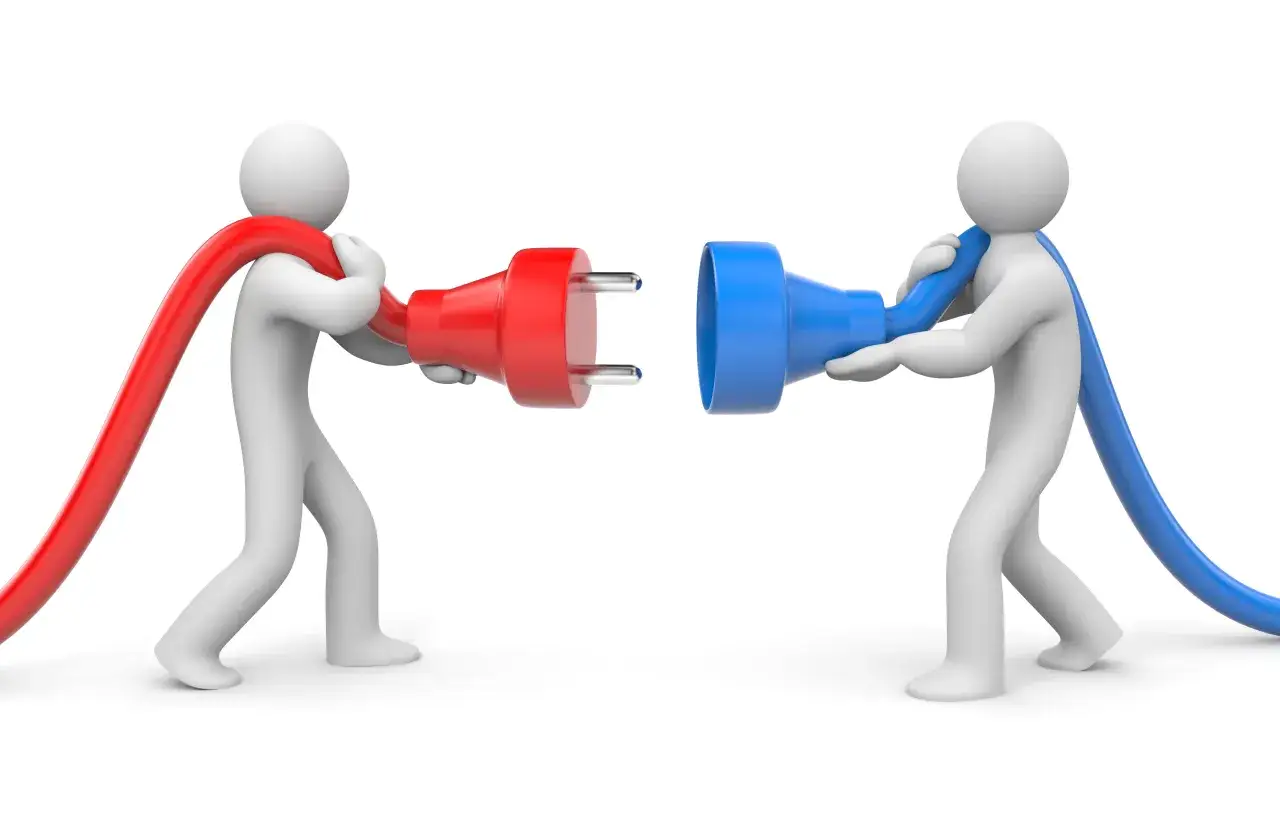 Dwie postacie, jedna z czerwonym, druga z niebieskim kablem, zbliżają się do siebie, by połączyć wtyczki. To jak zadawanie pytań do poznania się.