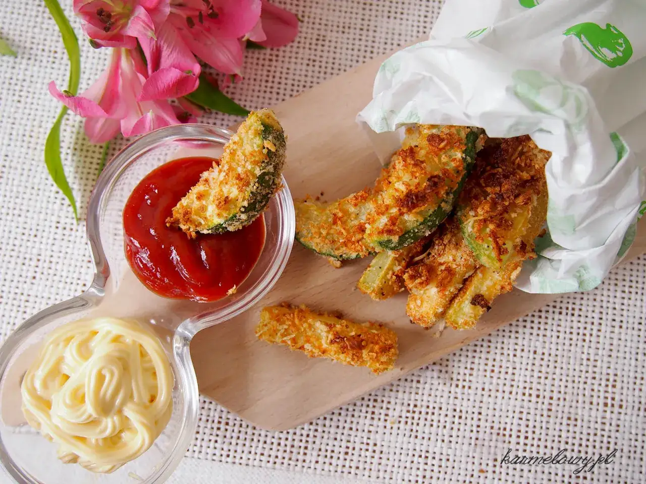 Chrupiące frytki z cukinii w panierce, podane z ketchupem i majonezem. Idealna przekąska na każdą okazję.