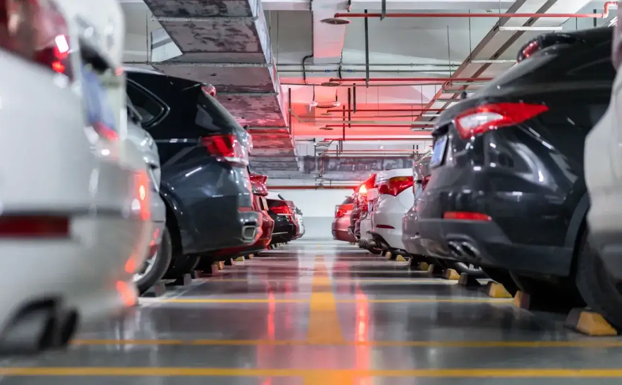 Rzędy samochodów spalinowych na parkingu podziemnym, być może czekających na nowy podatek od aut spalinowych.