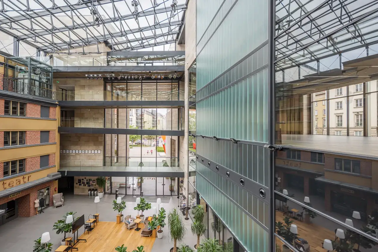 Wnętrze Teatru Capitol we Wrocławiu. Nowoczesna architektura z przeszklonym dachem i zielenią. Sprawdź repertuar!