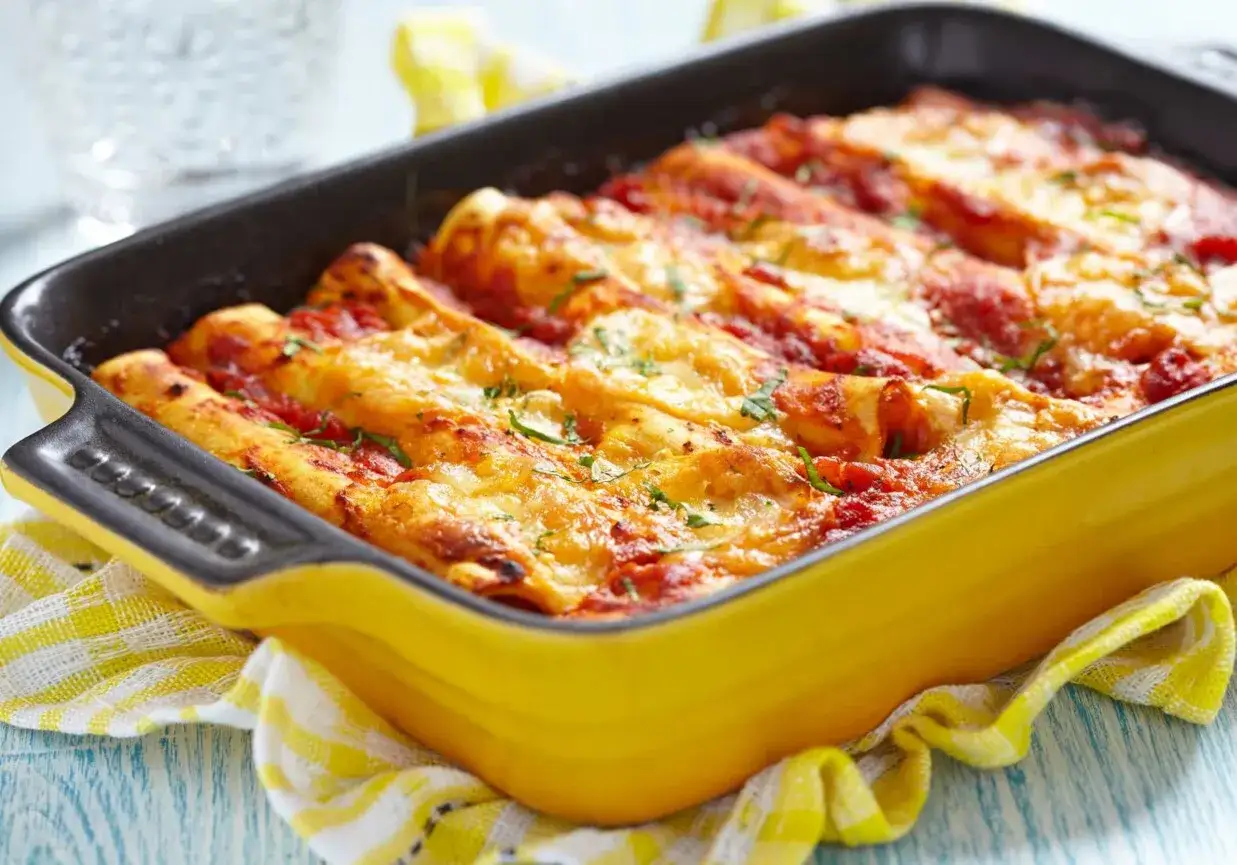 Pyszne cannelloni z mięsem mielonym, zapieczone pod sosem pomidorowym i serem, w ż&oacute;łtej brytfance.