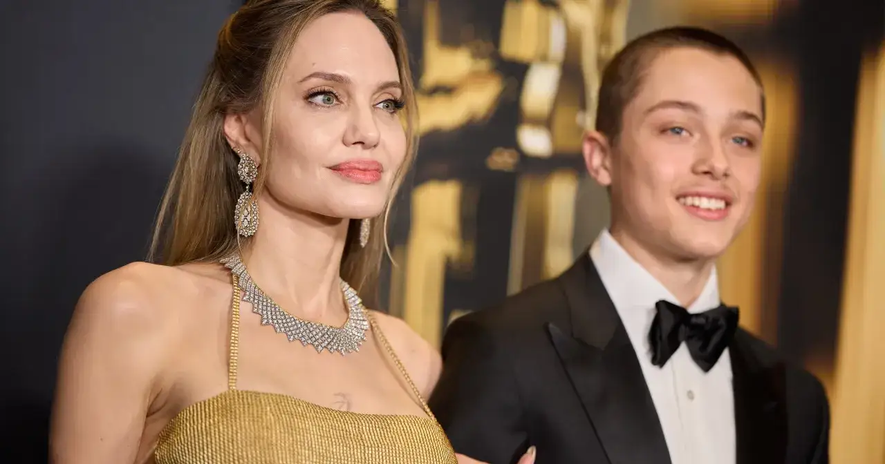 Angelina Jolie z synem Knoxem Leonem Jolie-Pittem na czerwonym dywanie. Ona w złotej sukni i biżuterii, on w eleganckim smokingu.