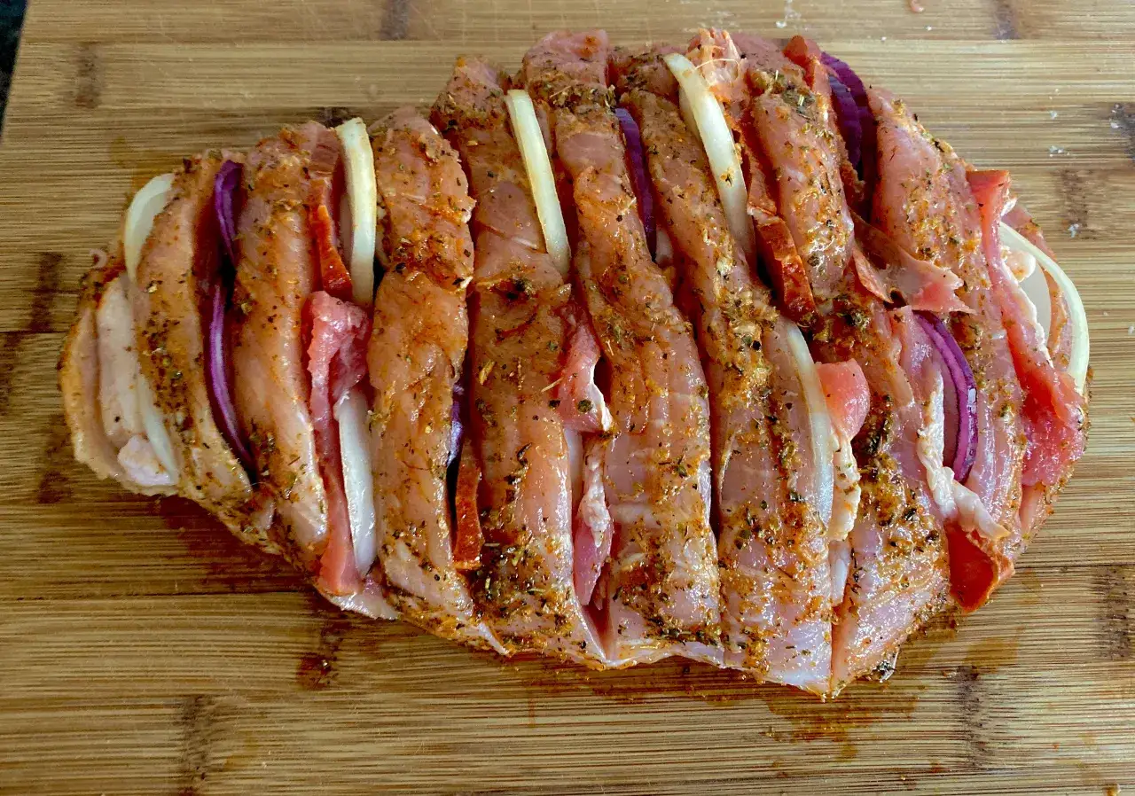 Szynka wieprzowa nacięta i nadziana cebulą, przyprawiona. Idealna do pieczenia.