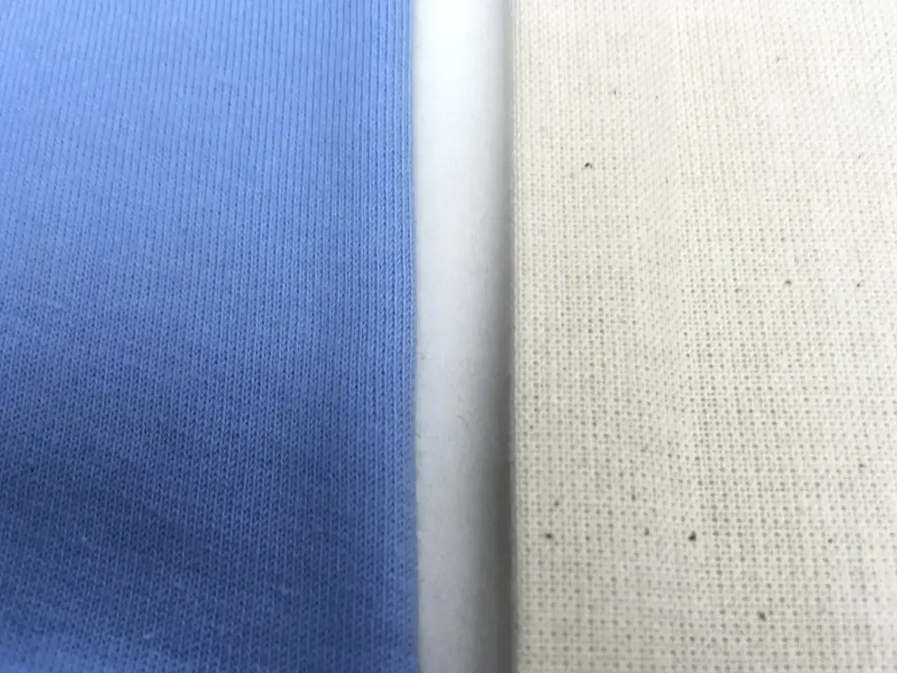 Dwa rodzaje materiału: niebieski, prążkowany, idealny na spodnie dresowe, i ecru, z widocznym splotem.