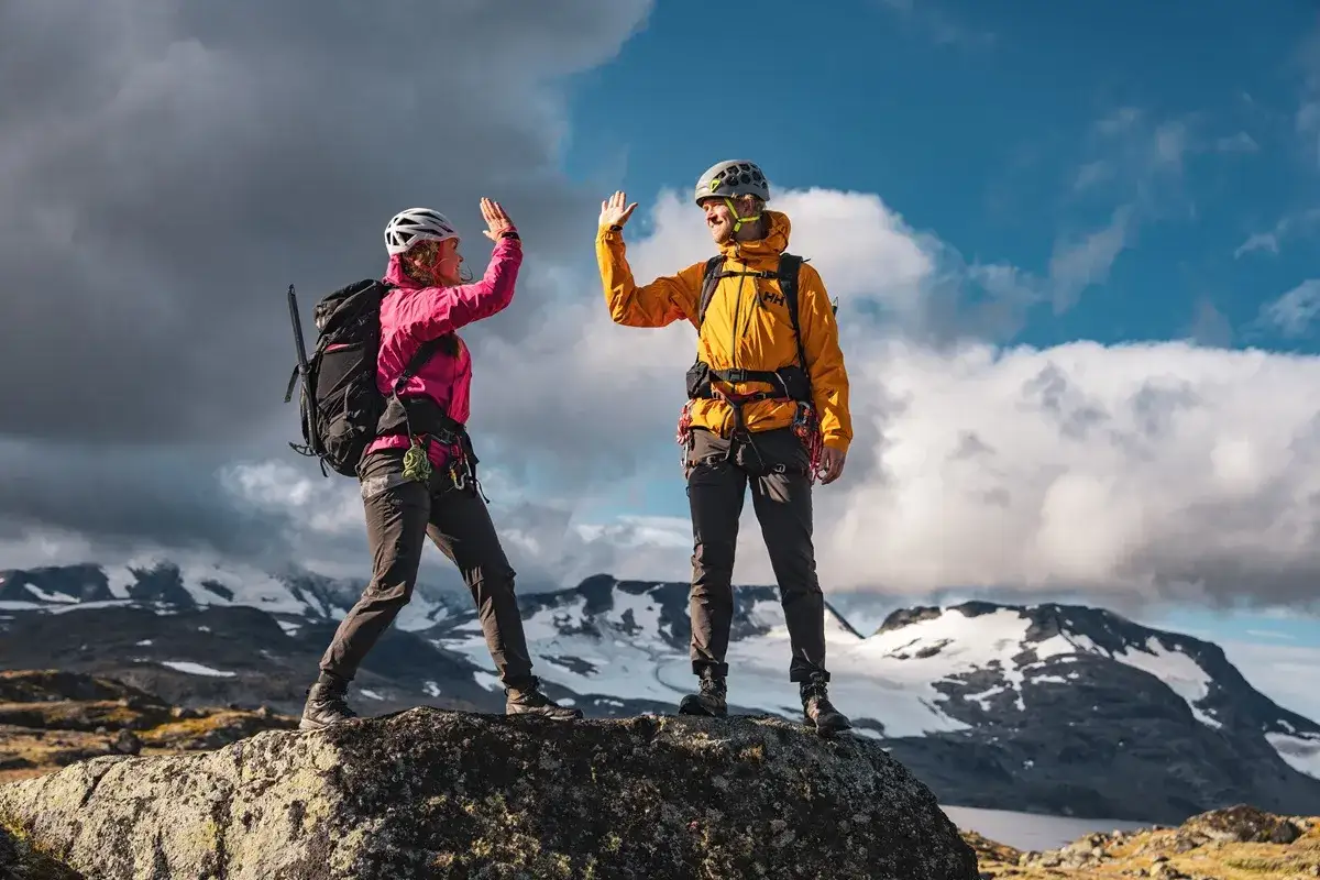 Dw&oacute;ch alpinist&oacute;w świętuje sukces na szczycie, pokonując przeklęte g&oacute;ry.