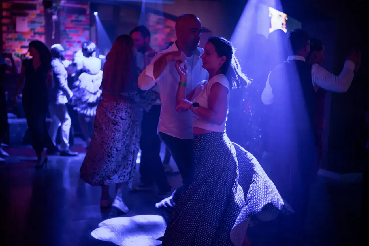 Para tańczy rumbę, taniec, z jakiego kraju pochodzi rumba, w klubie z niebieskim oświetleniem.