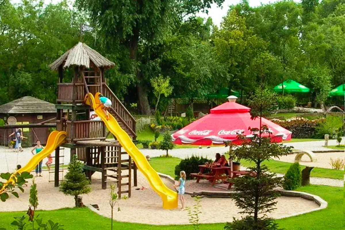 Dzieci bawią się na placu zabaw w Augustowie. Zjeżdżalnie i piaskownica to świetne augustów atrakcje dla dzieci.
