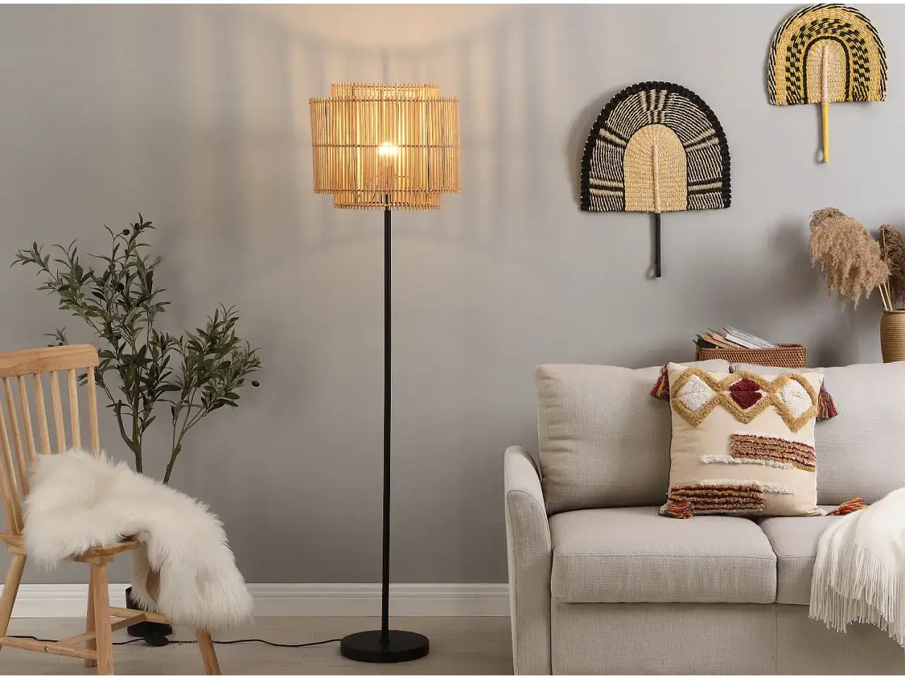 Przytulny salon z lampą podłogową boho, plecionymi ozdobami na ścianie i wygodną kanapą.