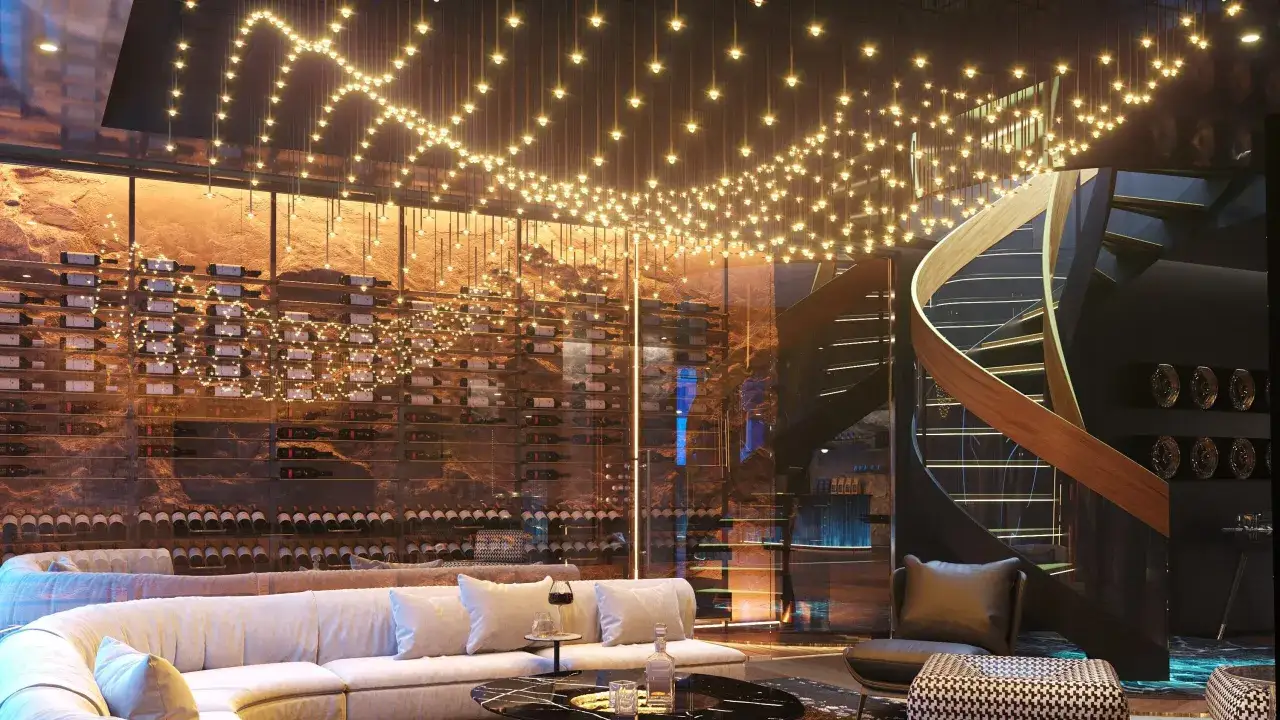 Nowoczesne wnętrze z winnicą i sofą. Projektant oświetlenia stworzył magiczną atmosferę dzięki tysiącom małych światełek.