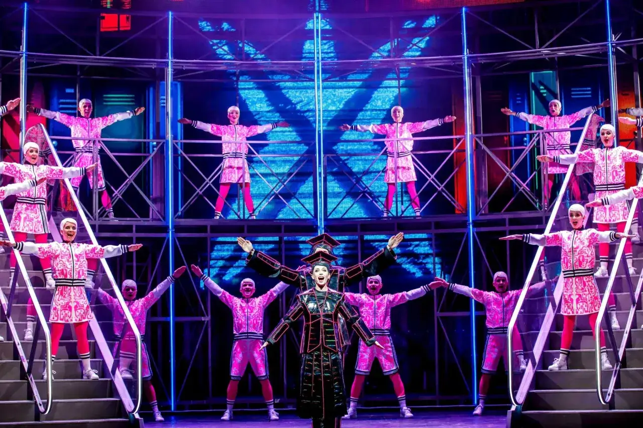 Tancerze w różowych strojach z czarnymi akcentami, tworzący dynamiczną scenę, część repertuaru teatru Roma.