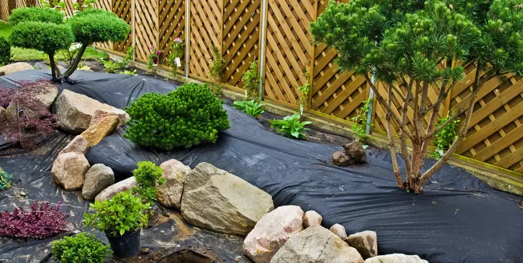 rozłożona agrowł&oacute;knina pod kamienie w ogrodzie