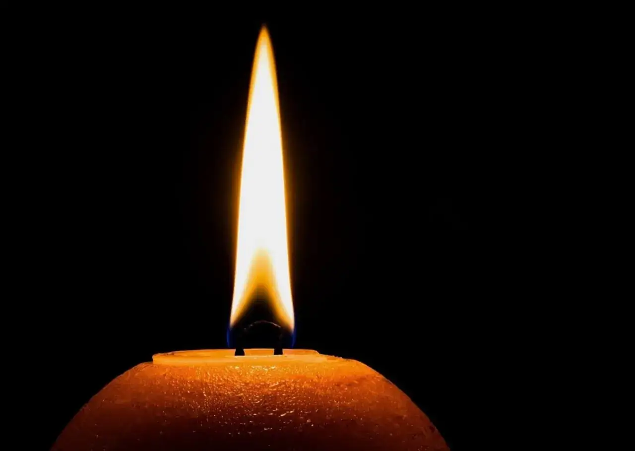Płonąca świeca na ciemnym tle. Może symbolizować pamięć i częste chodzenie na cmentarz.